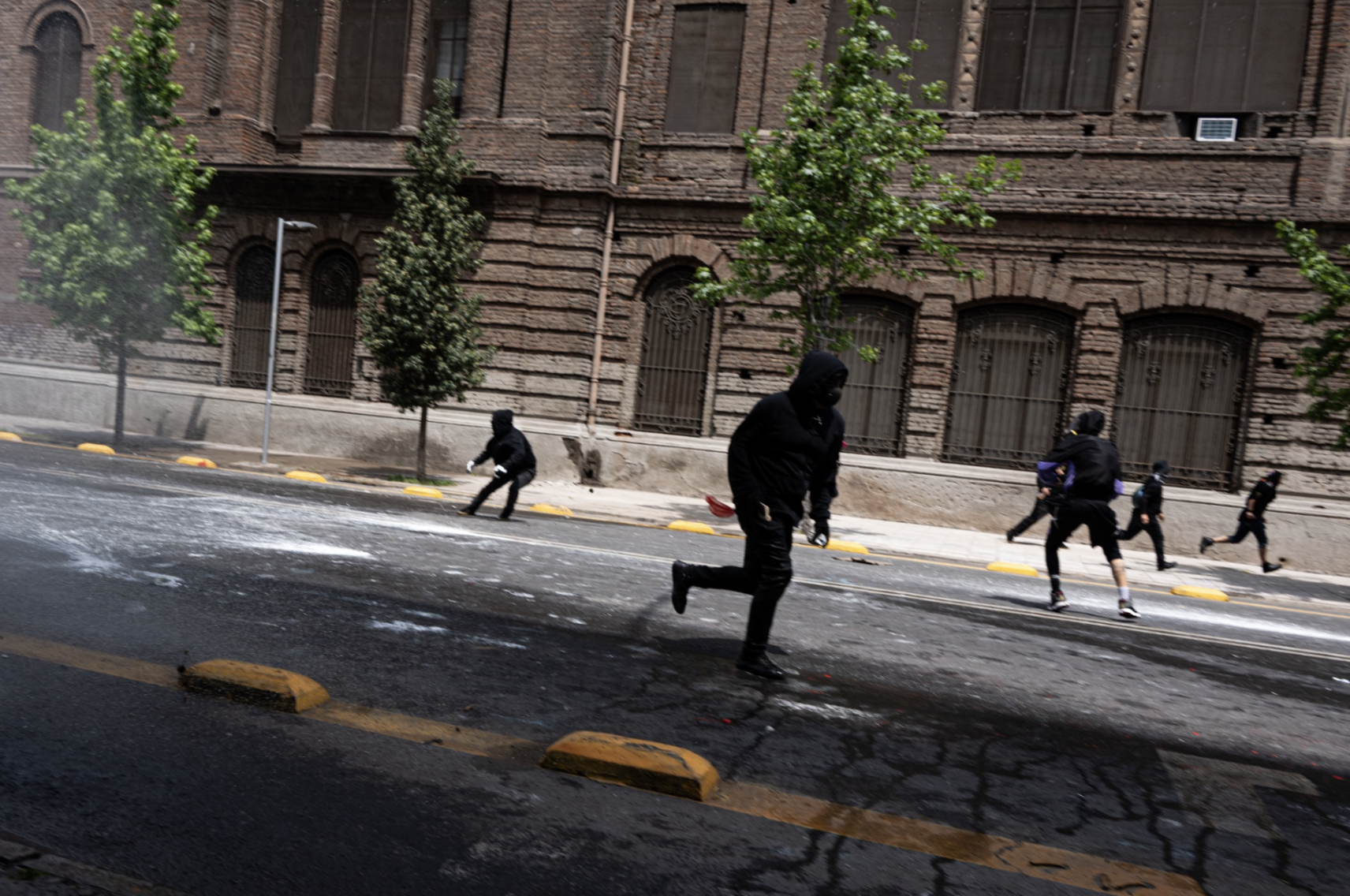 Manifestantes se alejan mientras los carabineros utilizan gas lacrimógeno y cañones de agua contra la multitud. (Foto: Ike Wood / Interferencia.cl)