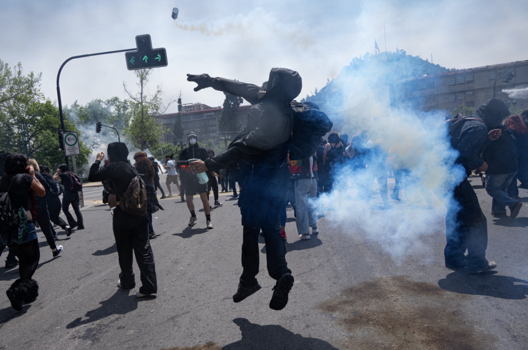 Un manifestante recoge una lata de gas lacrimógena para devolver a las fuerzas especiales. (Foto: Ike Wood / Interferencia.cl)