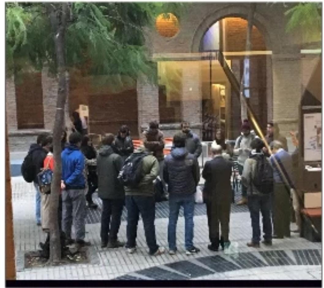 Profesores y estudiantes orando en el patio de Derecho UC.