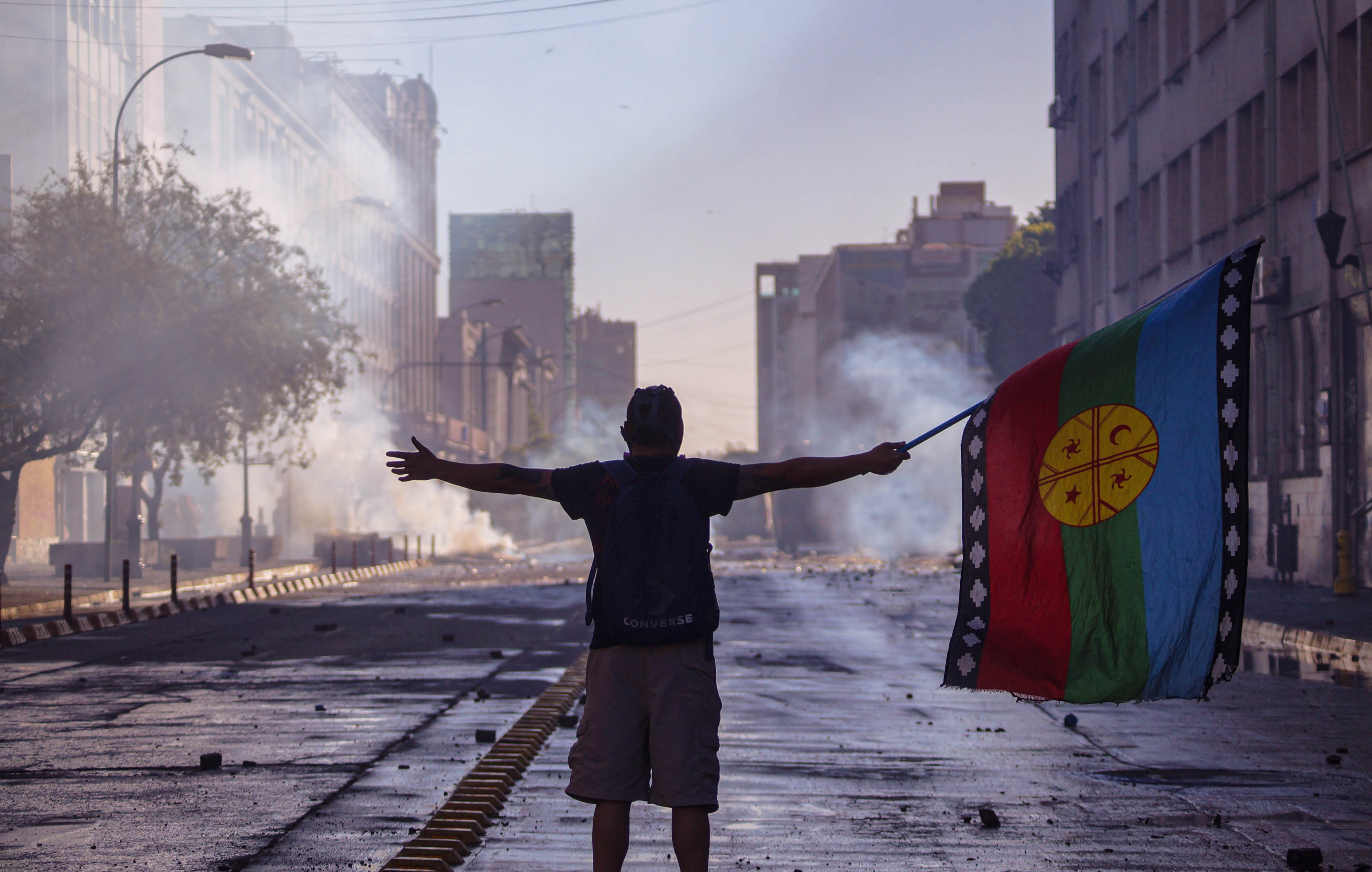Un hombre levantando la bandera Mapuche por la calle O'Higgins después de una marcha que reunió miles de personas. Concepción, Octubre 2019. Un hombre levantando la bandera Mapuche por la calle O'Higgins después de una marcha que reunió miles de personas. Concepción, Octubre 2019.