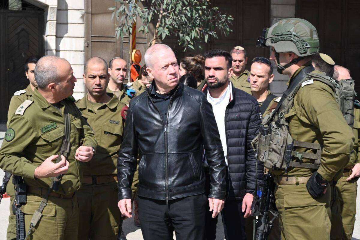El Ministro Yoav Gallan, vestido entero de negro, junto a militares israelíes.