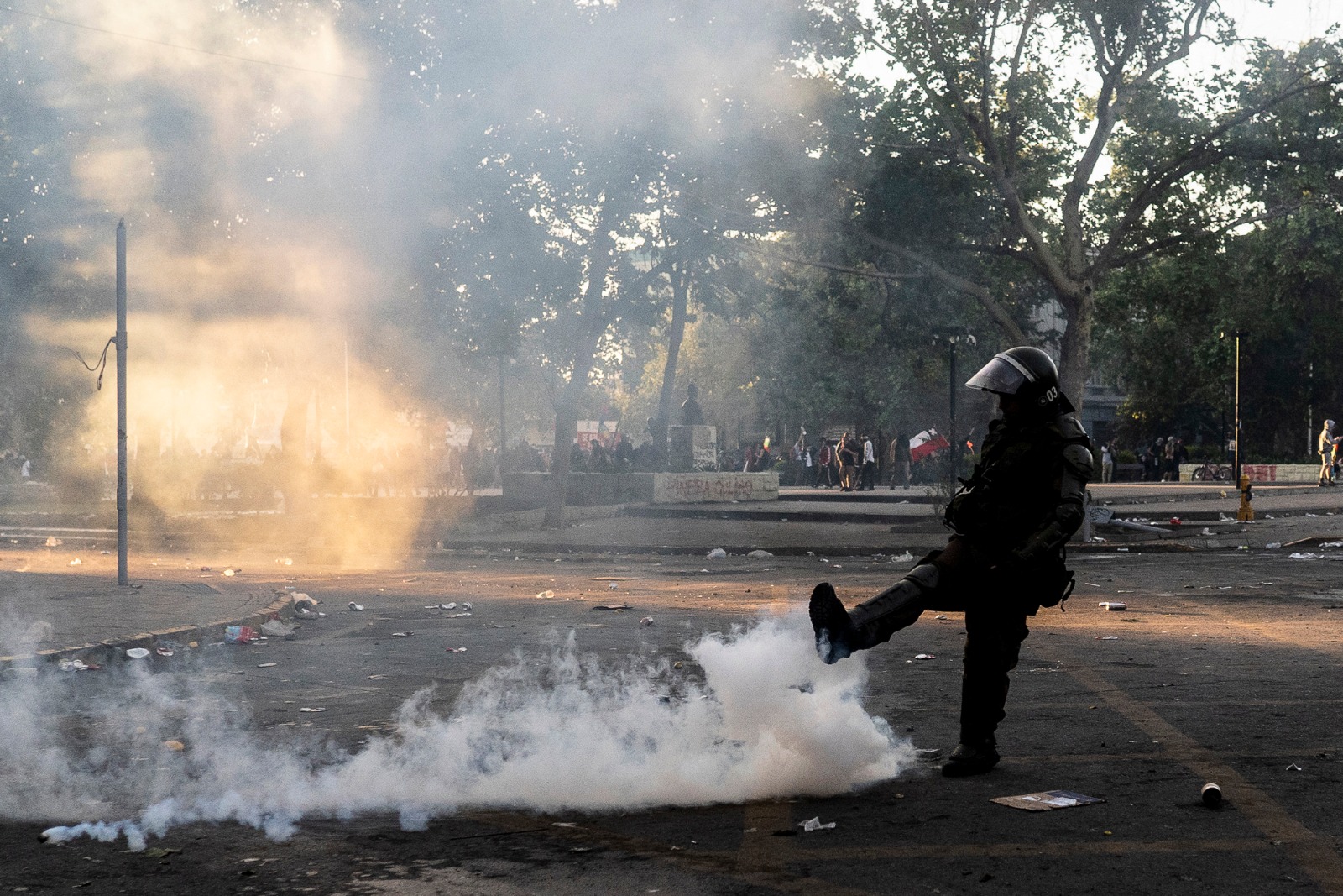 Carabinero pateando munición lacrimógena. Créditos: Gabriel Pecot
