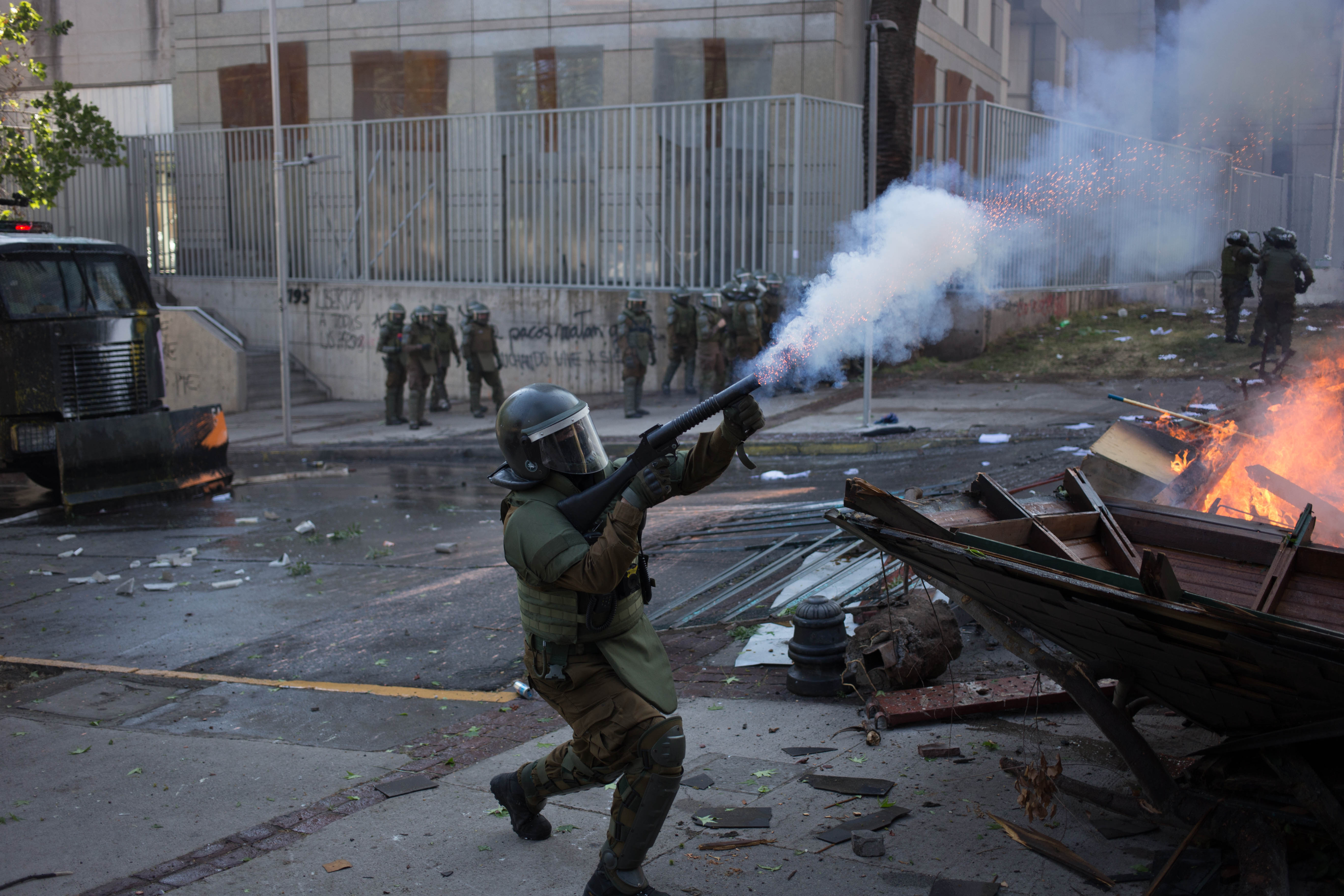 Carabinero de Control del Orden Pública lanza bomba lacrimógena a manifestantes en alrededores de Plaza Dignidad (Ex Plaza Italia) durante conmemoración del primer aniversario de la revuelta del 18 de Octubre de 2019. Carabinero de Control del Orden Pública lanza bomba lacrimógena a manifestantes en alrededores de Plaza Dignidad (Ex Plaza Italia) durante conmemoración del primer aniversario de la revuelta del 18 de Octubre de 2019.