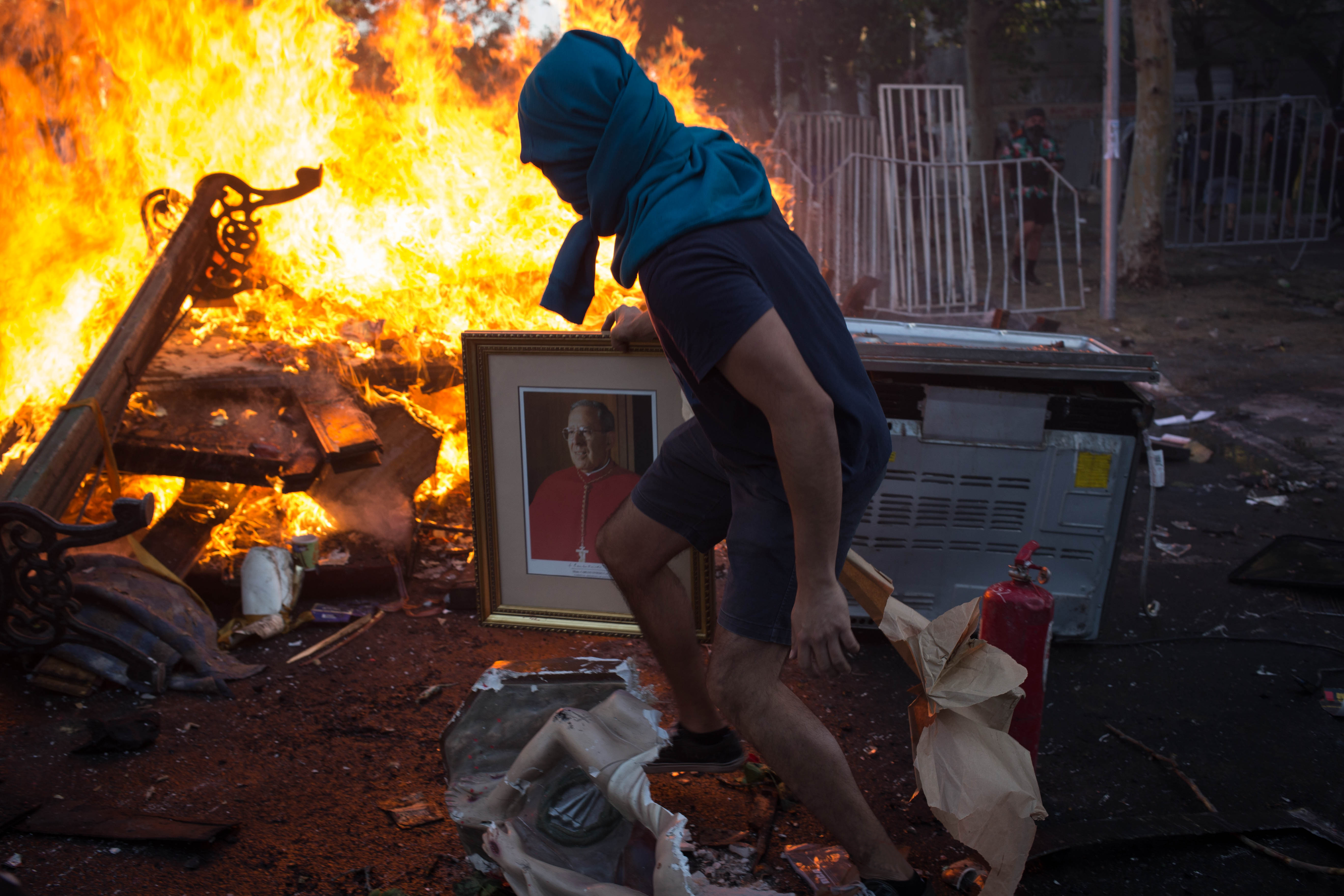Manifestante lanza una imagen religiosa a barricada en alrededores de Plaza Dignidad (Ex Plaza Italia) durante conmemoración del primer aniversario de la revuelta del 18 de Octubre de 2019. Manifestante lanza una imagen religiosa a barricada en alrededores de Plaza Dignidad (Ex Plaza Italia) durante conmemoración del primer aniversario de la revuelta del 18 de Octubre de 2019.