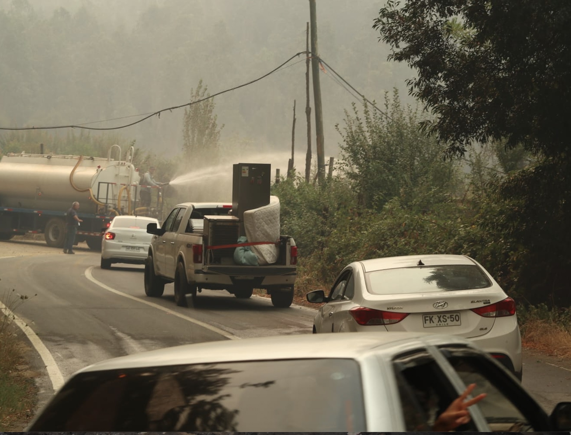 Residentes de Tricauco huyen de sus hogares mientras camiones aljibe combaten focos de incendio. Crédito: Sebastián Villarroel/Agencia Uno. Residentes de Tricauco huyen de sus hogares mientras camiones aljibe combaten focos de incendio. Crédito: Sebastián Villarroel/Agencia Uno.