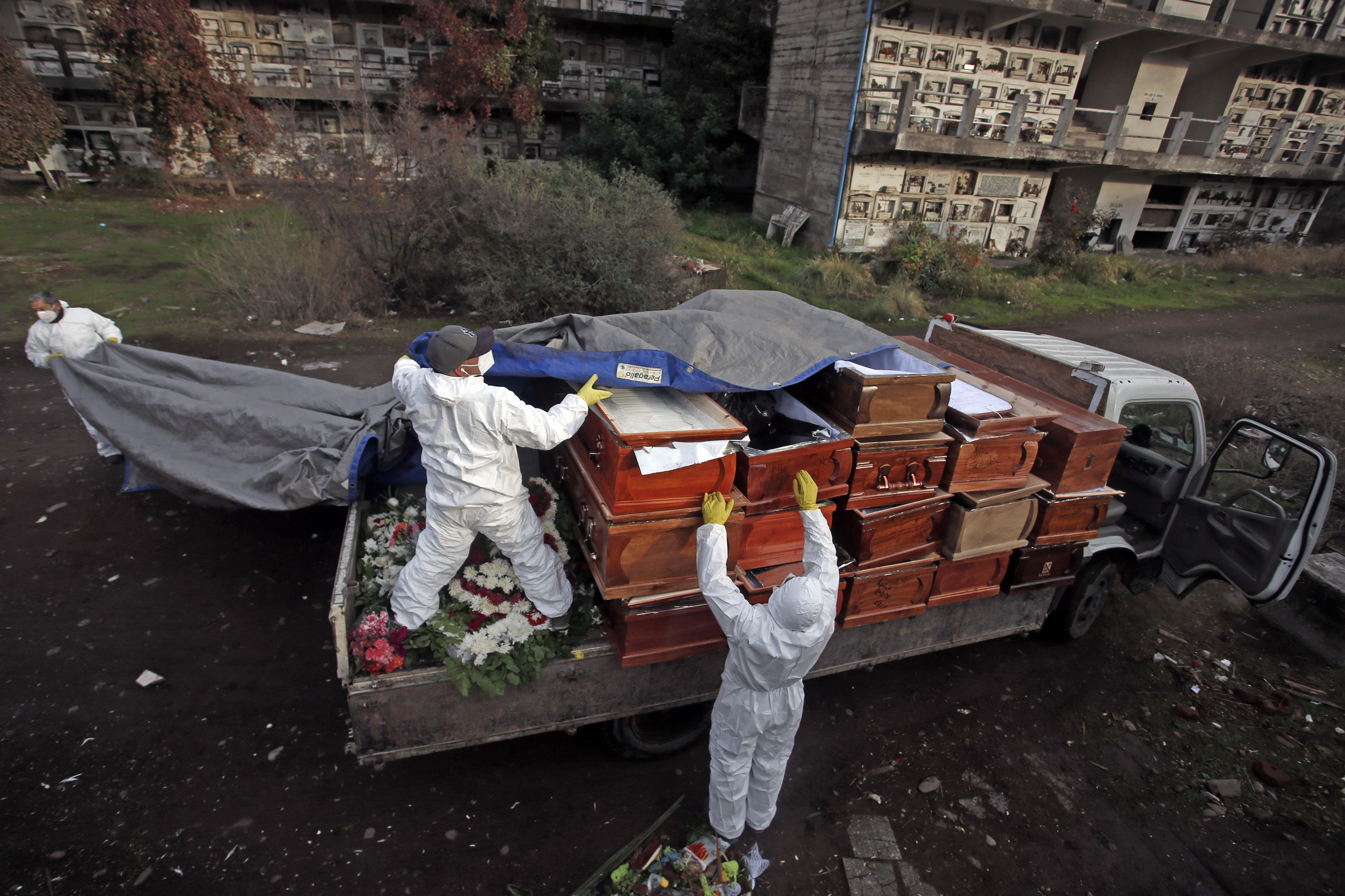 Trabajadores apilan ataúdes de personas que han sido incineradas recientemente. Cementerio de La Recoleta. 28 de Junio de 2020.