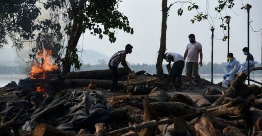 Trabajadores municipales incineran a víctimas de la covid-19 en Guwahati, India, el 25 de abril de 2021. Shutterstock / Talukdar David