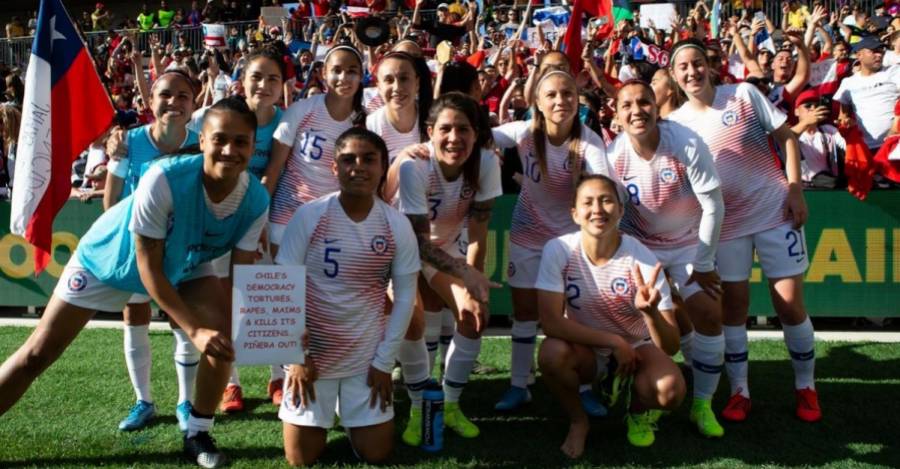La jugadora Fernanda Pinilla muestra un letrero contra Piñera en un amistoso en Australia en 2019.