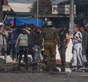 Comerciantes ambulantes dialogan con Carabineros minutos después del disparo a la reportera. Fotografía: Antu Riffo. 