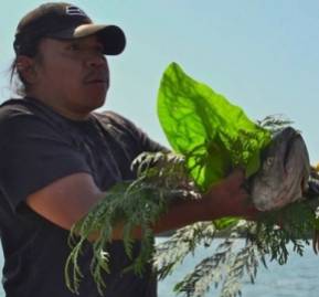 Miembro del pueblo Swinomish en ceremonia que agredece al salmón. Crédito: Saskia de Melker Miembro del pueblo Swinomish en ceremonia que agredece al salmón. Crédito: Saskia de Melker