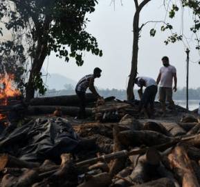 Trabajadores municipales incineran a víctimas de la covid-19 en Guwahati, India, el 25 de abril de 2021. Shutterstock / Talukdar David