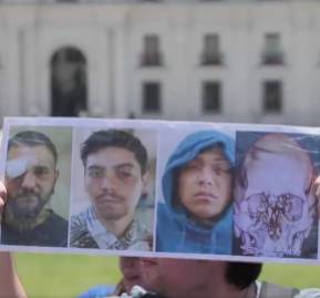 Un manifestante muestra una imagen de los heridos frente a La Moneda en la marcha de la Coordinadora de Víctimas de Traumas Oculares. Un manifestante muestra una imagen de los heridos frente a La Moneda en la marcha de la Coordinadora de Víctimas de Traumas Oculares.